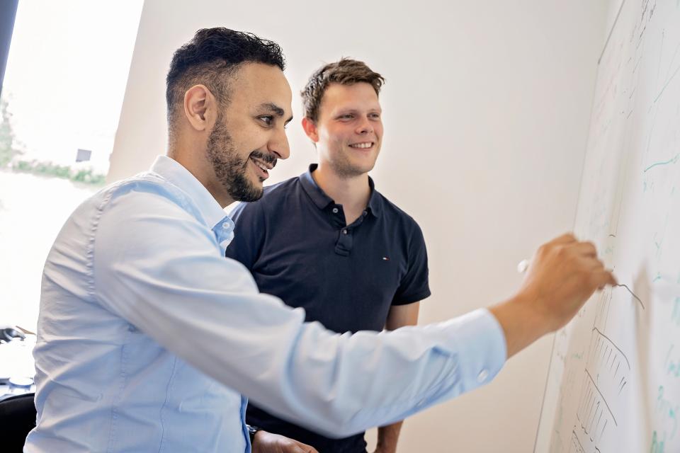 To medarbejdere, der kigger på en tavle